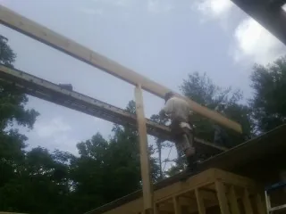 Carpenter setting a ridge beam over a new addition frame — Ice Dam Removal by Roofing Brothers in Chesterville