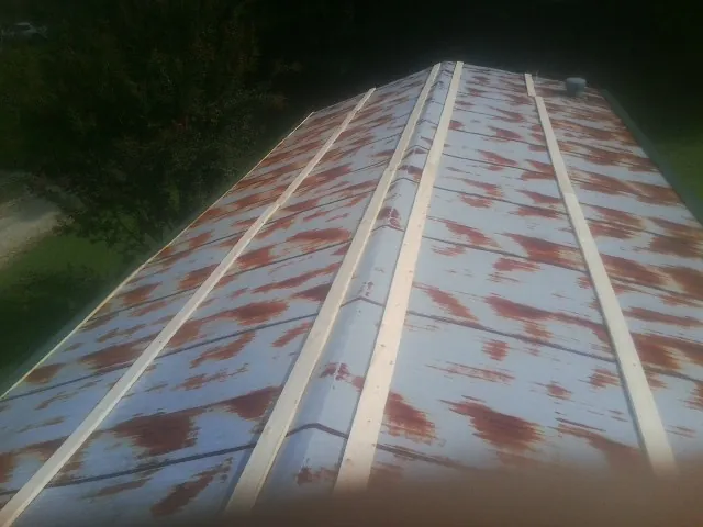 Rusted metal roof panels with new wood purlins before replacement — Storm Damage Roof Repair in Chesterville by Roofing Brothers