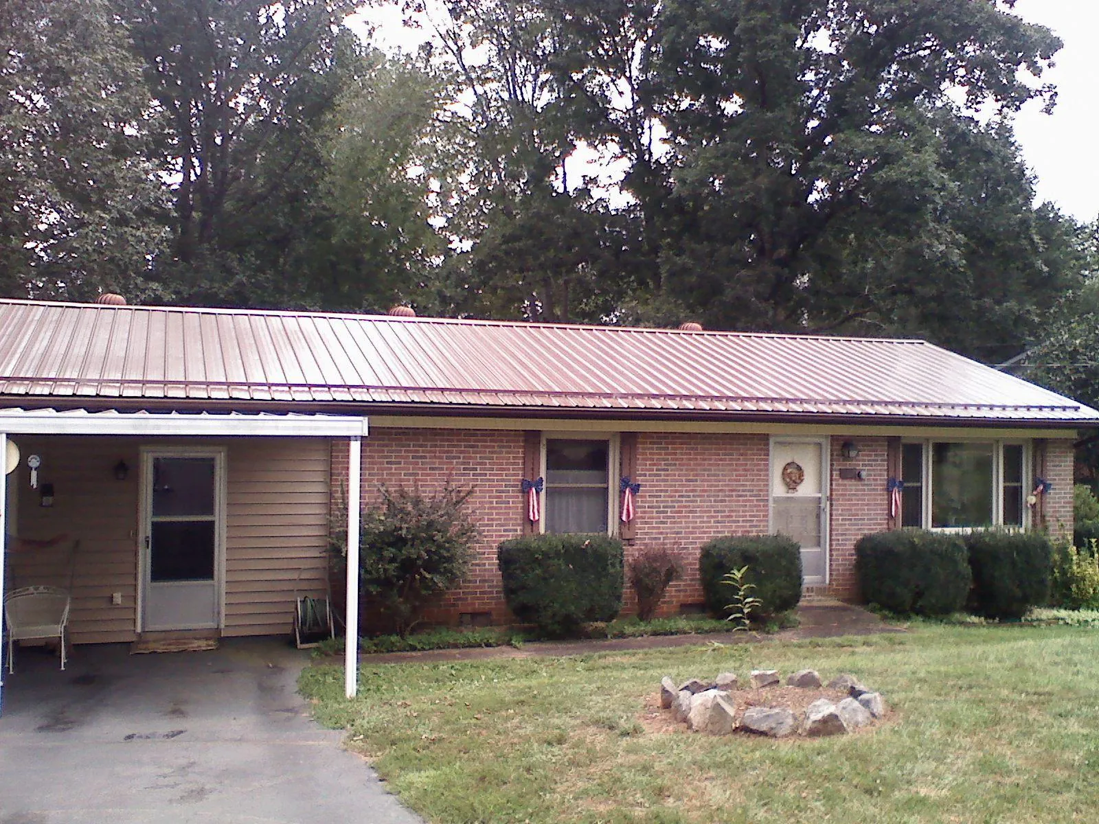 Bronze metal roof and carport on a brick ranch home — Roof Repair work by our crew in Chesterville